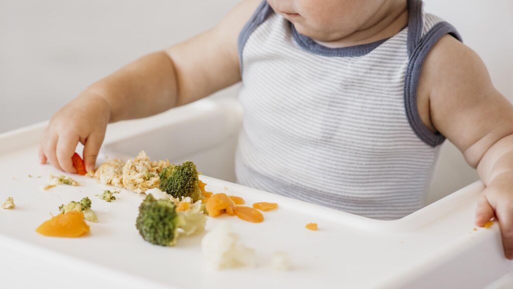 cute baby boy highchair choosing what eat 2